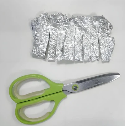 cutting aluminum foil with scissors cutting aluminum foil with scissors